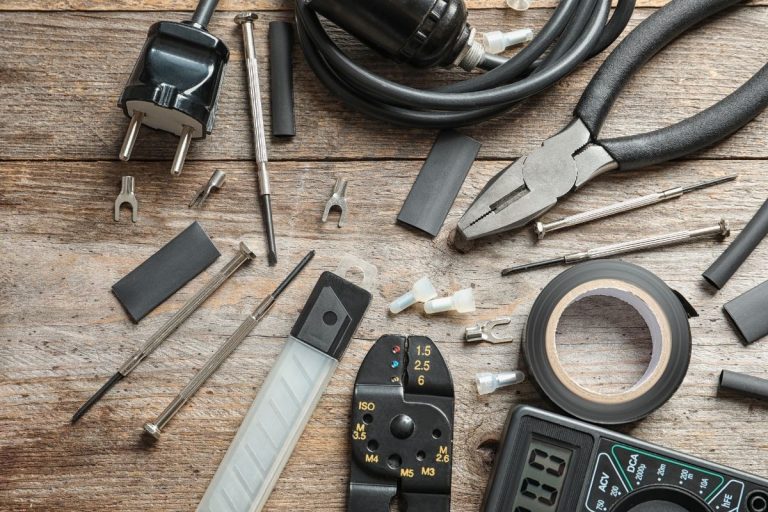 A wooden table displaying a variety of tools, including wrenches, screwdrivers, and pliers, arranged neatly.